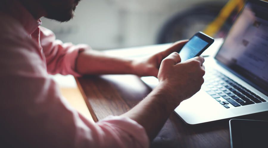man looking at phone and computer