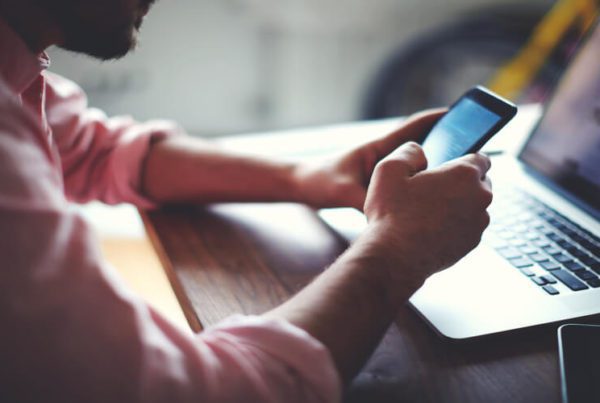 Person looking at phone and computer